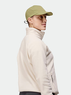 Person in a lightweight Halti Aero II Cap and light beige jacket, standing sideways against a plain background.