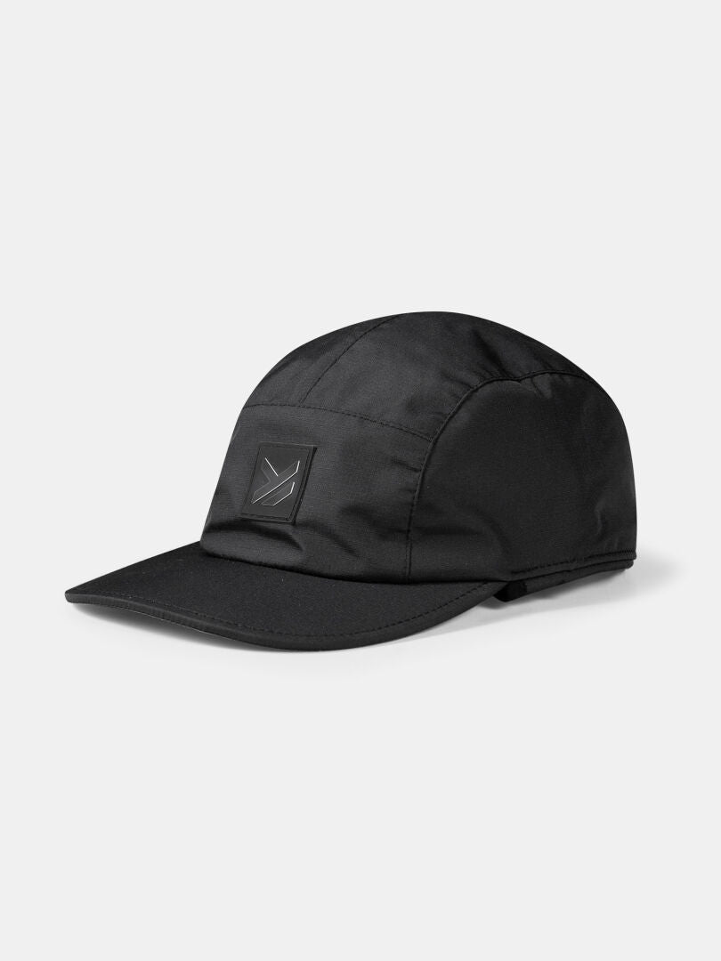 The Halti Skutta Cap is a black five-panel hiking hat with a curved brim and front rectangular patch logo.