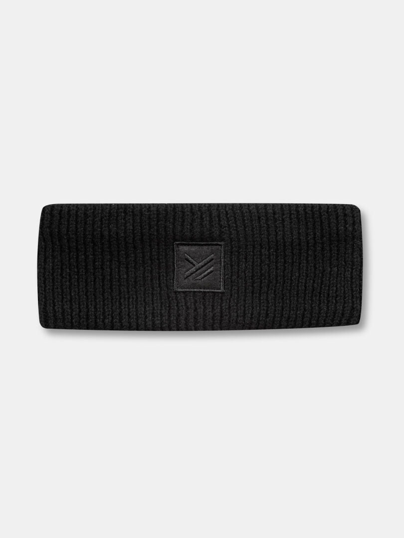The Halti Huurre Headband is a black ribbed wool accessory with a geometric logo patch, ideal for winter warmth.