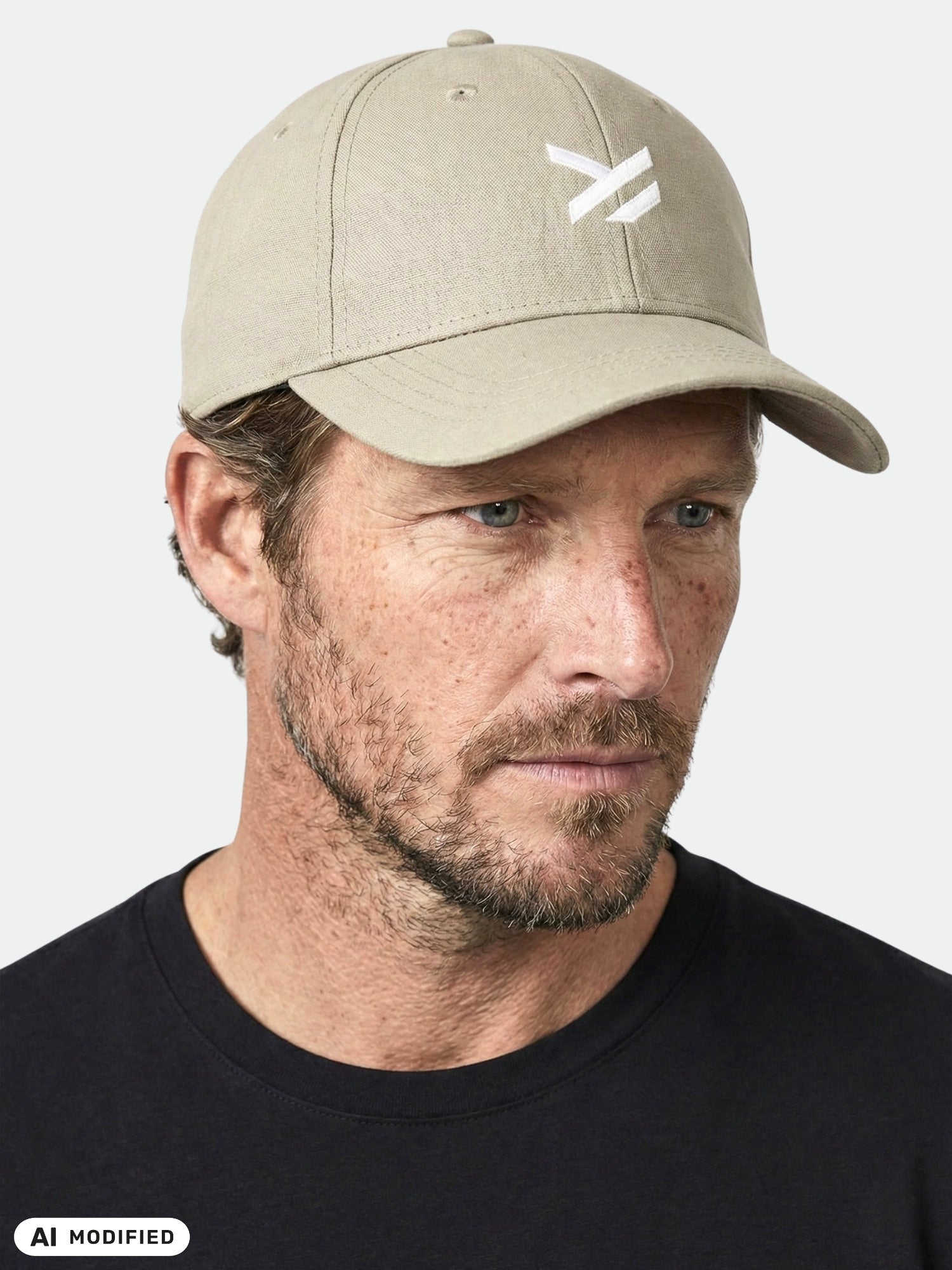 Man with a trimmed beard wears a Halti Notsgi Cap and black shirt against a plain light background.
