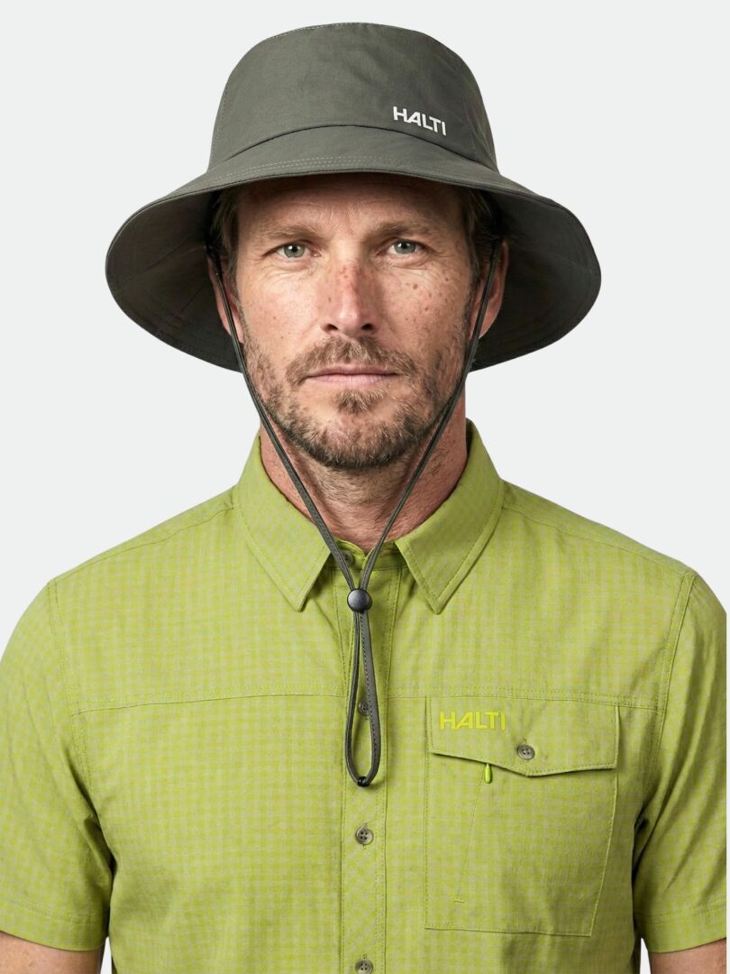 Man wearing a green shirt and the Halti Luovi Bucket Hat in gray with UPF 90+ protection, looking at the camera.