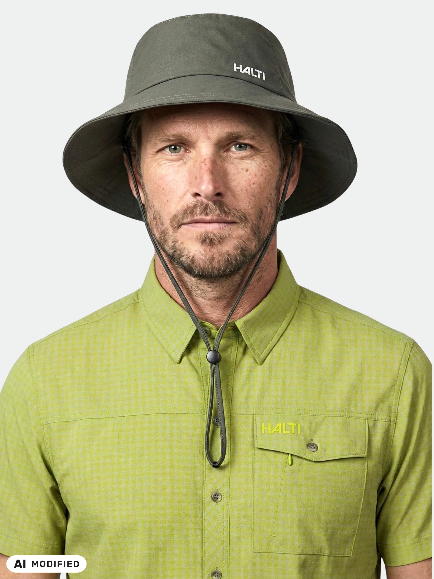 A man wears the Halti Luovi Bucket Hat with UPF 90+ and a green checkered shirt, facing forward against a plain background.