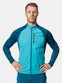 A man in a Halti Tracks Mens Seamless Jacket stands hands on hips, ready for outdoor workouts against a plain background.