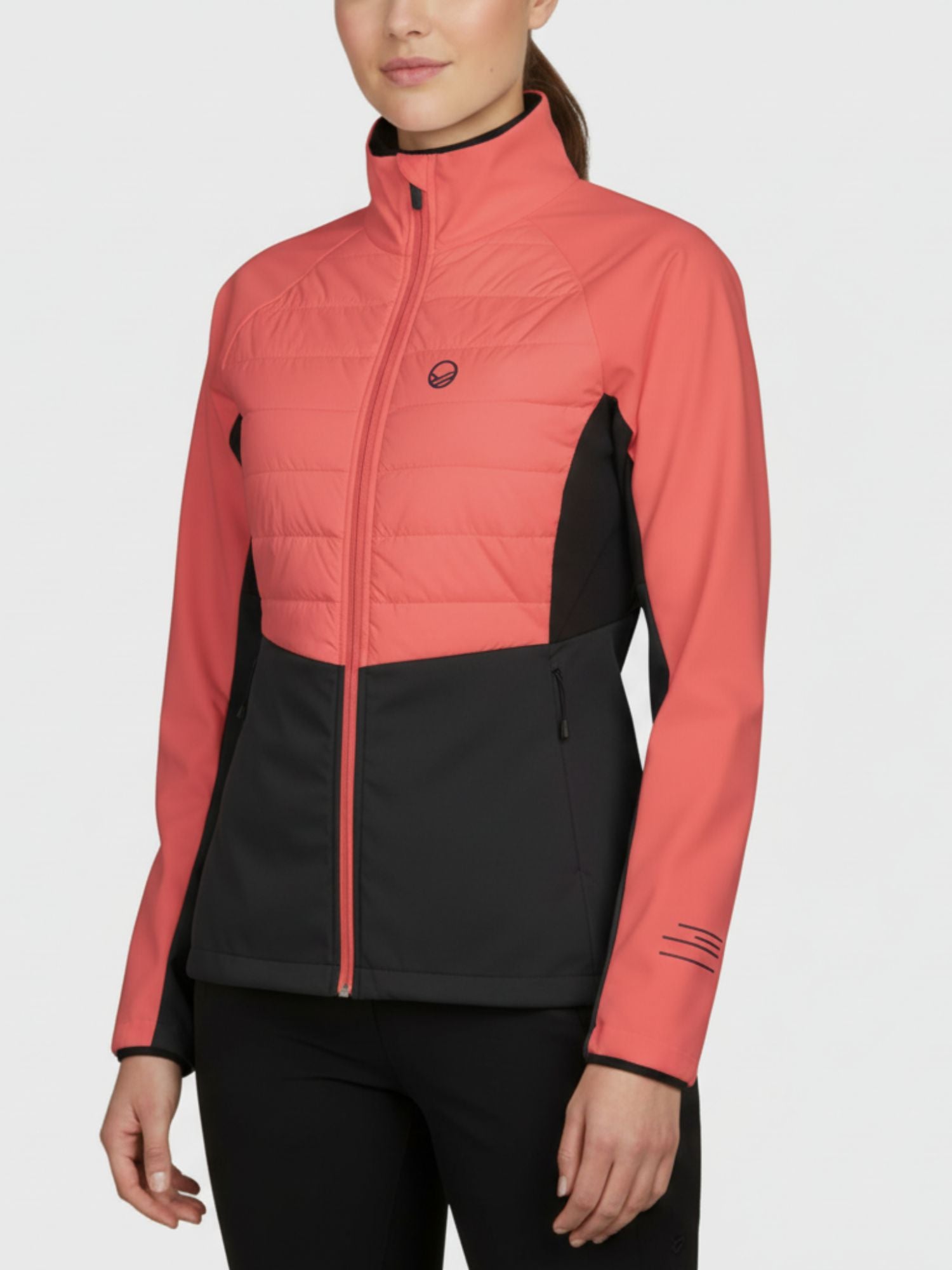 A woman in a Halti Vinha Hybrid XCT Jacket stands against a plain, light background.