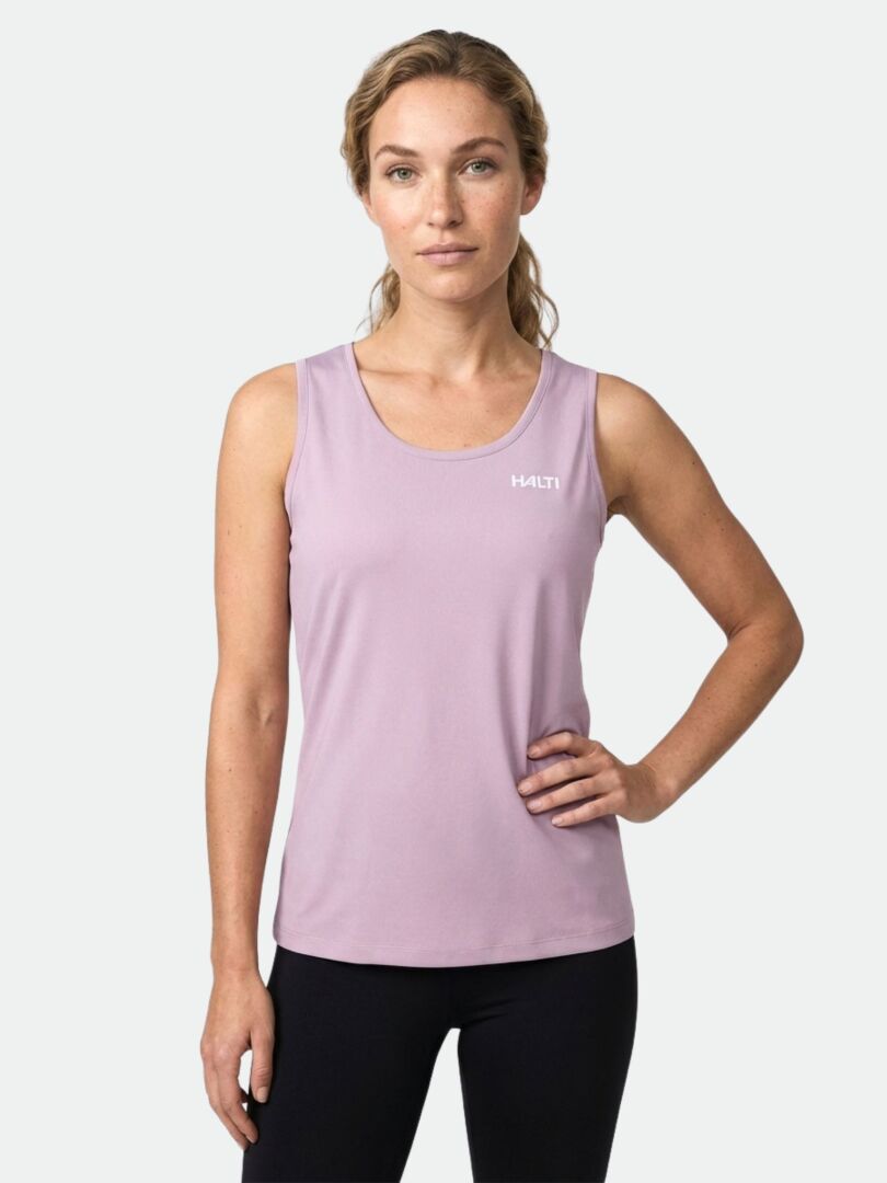Woman wearing a Halti Salves Top Women's tank and black leggings, standing against a plain light background.