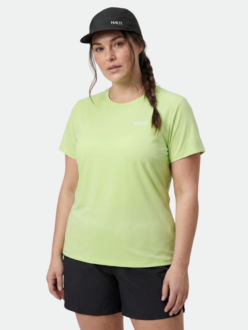 A woman in a Halti Salves T-shirt Women's Plus stands against a plain background, paired with black shorts and a cap.