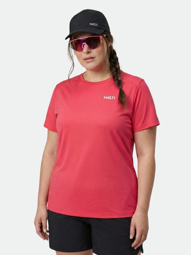 A woman in a red Halti Salves T-shirt Women's Plus, black shorts, Halti cap, and red sunglasses stands facing forward.