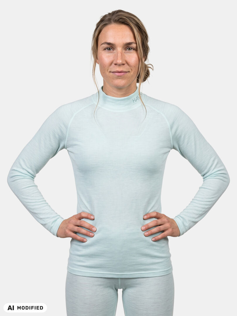 Woman wearing a light blue Halti Neva merino base layer set with her hands on her hips.