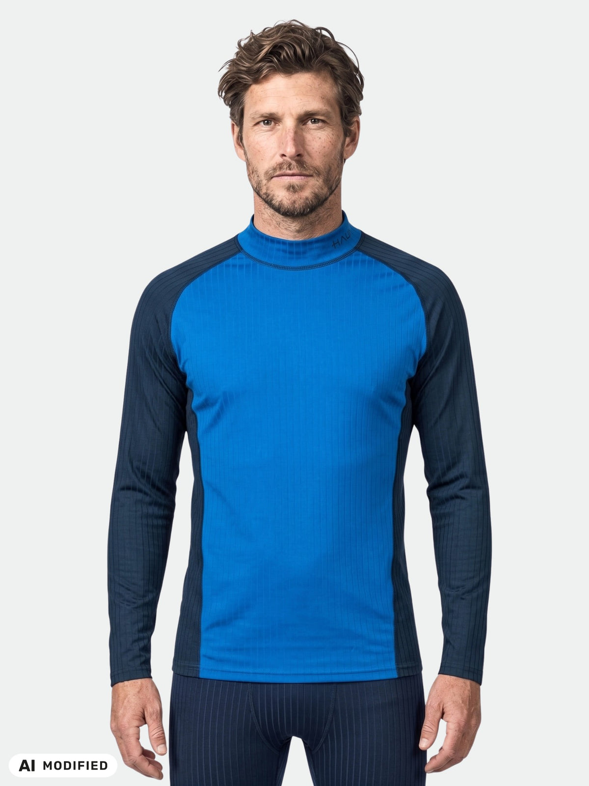A man wears the Halti Dual Base Layer Set Men’s, featuring blue with black sleeves, against a plain white background.