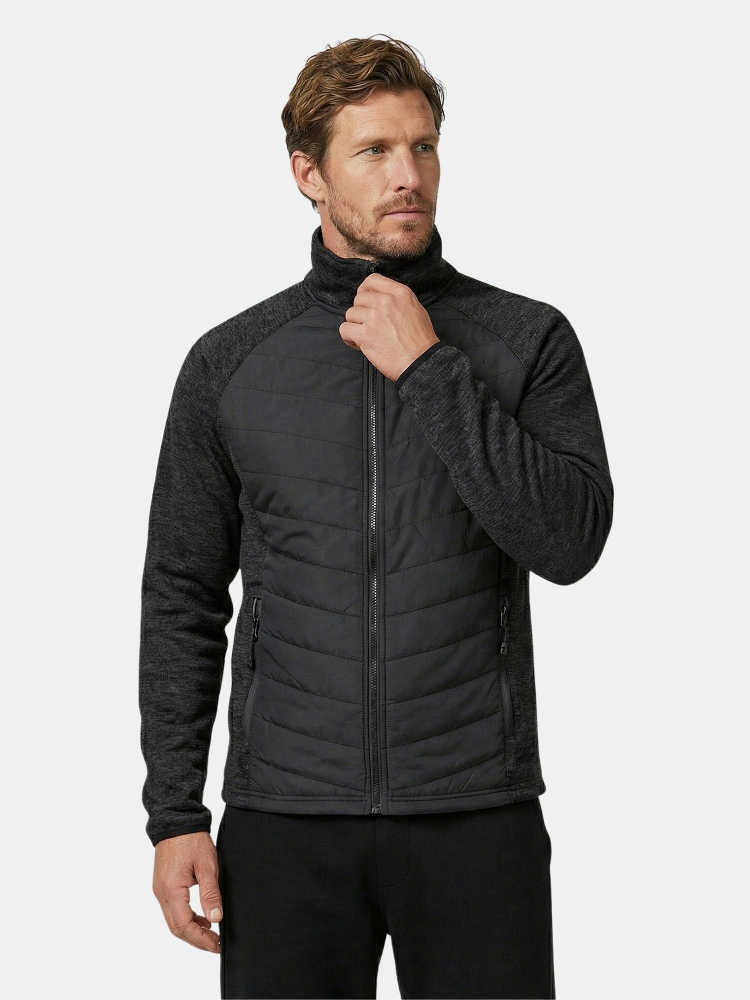 Man wearing the Halti Streams Hybrid Layer Jacket, featuring quilted panels, against a plain light background.