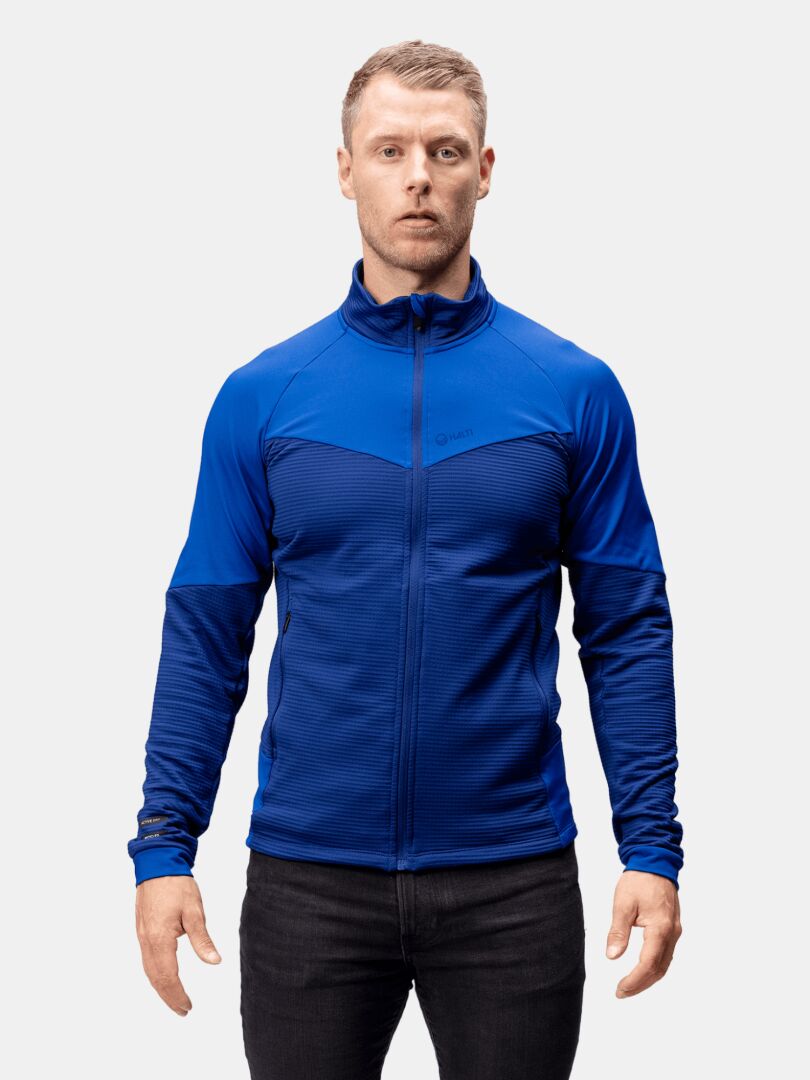 A man stands facing forward in the Halti HeatGrid Layer Jacket Men's against a plain light background.