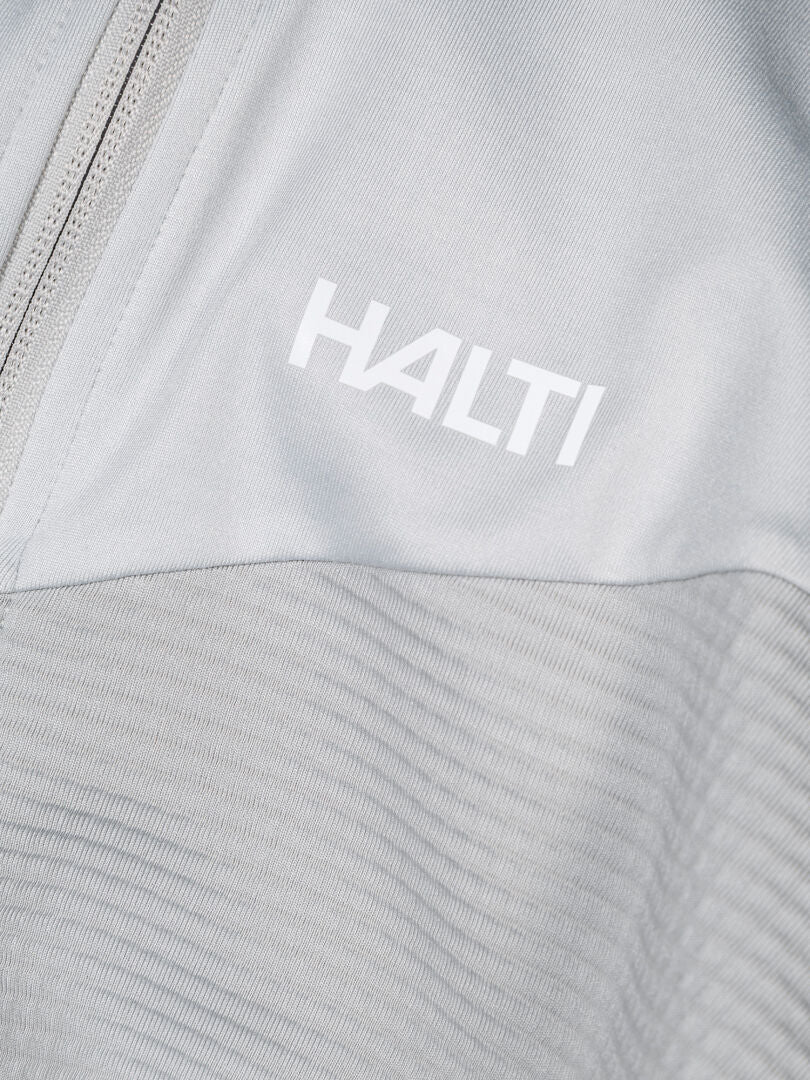 Close-up of Halti HeatGrid Layer Jacket Men's in light gray with zipper and white Halti logo on chest, made from recycled polyester.