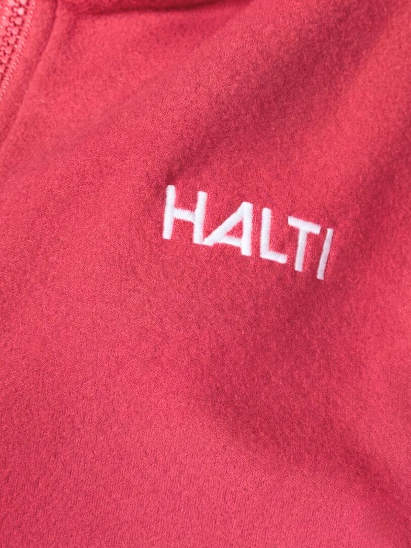 Close-up of the Halti Rockmoon Fleece Jacket Women's, a pink technical midlayer with zipper and white HALTI logo.