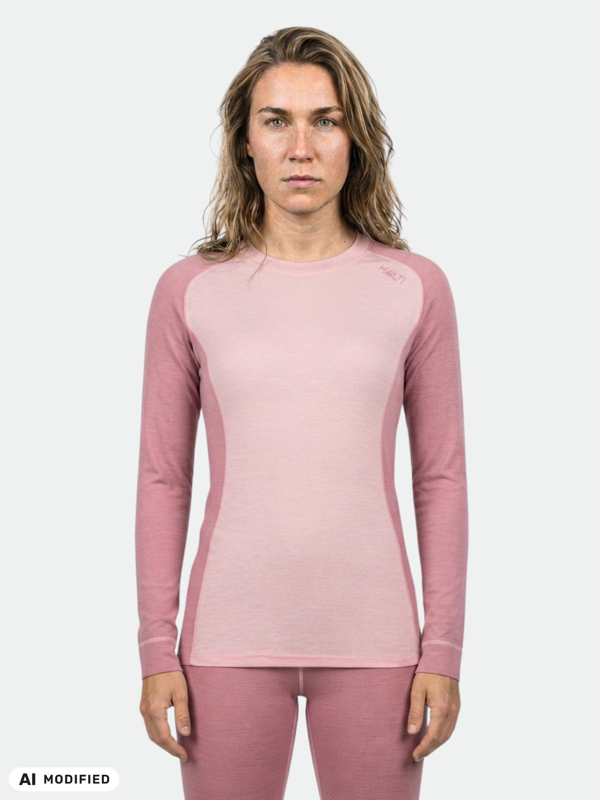 A woman wears the Halti Hossa II Merino Base Layer Set in light pink, standing against a plain background.