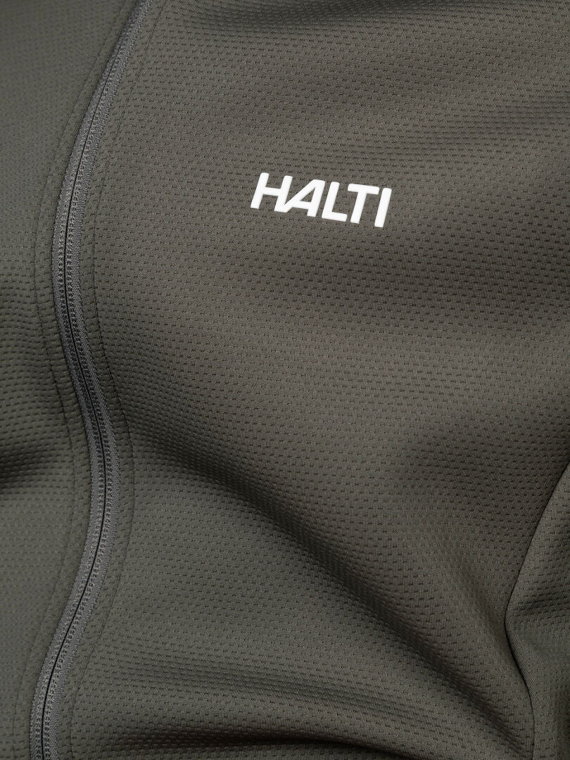 Close-up of Halti Kivikko Layer Jacket Men’s in dark gray, ideal for outdoor training. Features chest logo and zipper detail.