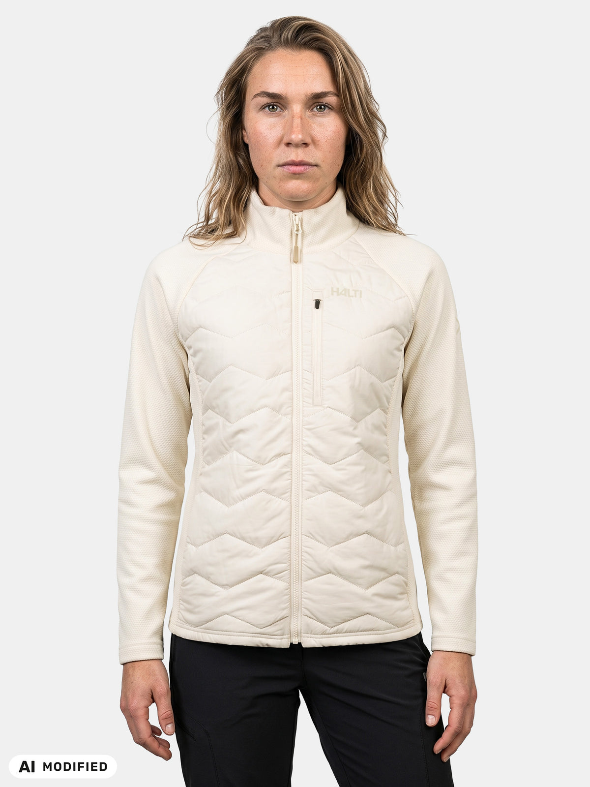 Woman in a cream-colored Halti Suomis Hybrid Layer Jacket with a quilted torso and textured sleeves.