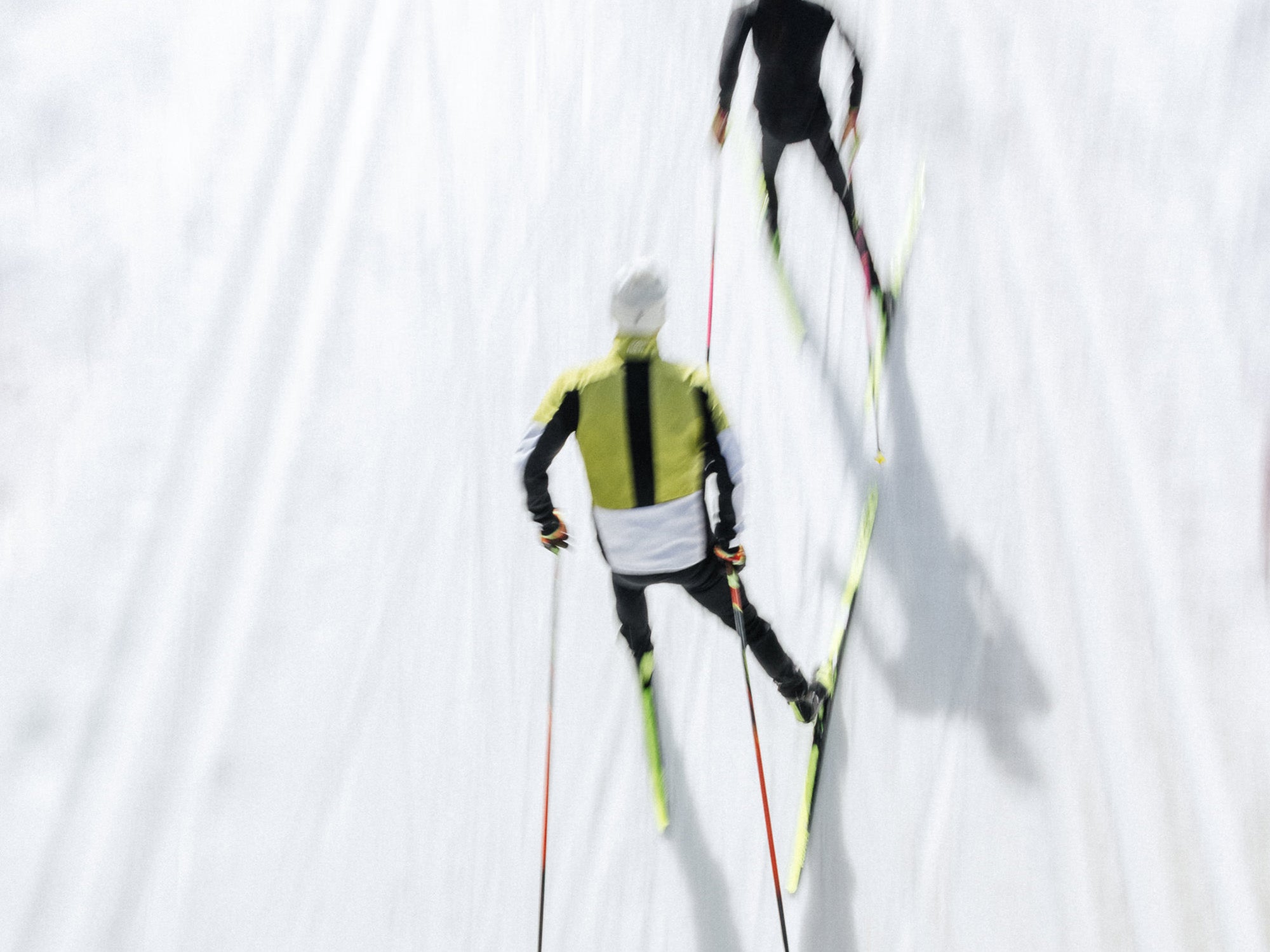 Two people on skis against a white background